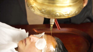 Student performing Shirodhara during Panchakarma Technician Certification Training at Kerala Ayurveda Academy